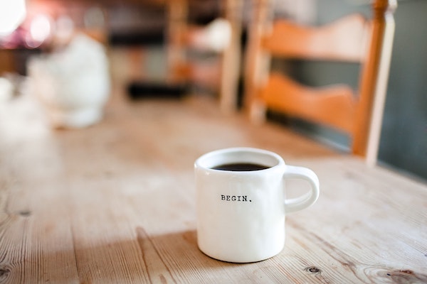 coffee cup with "begin" on it